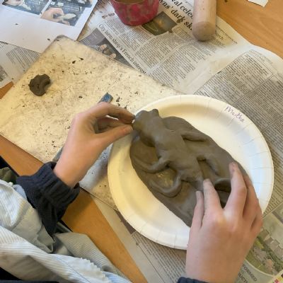 Children making clay lizards